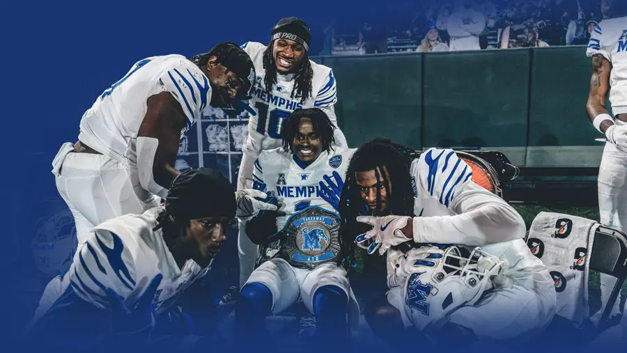 football players posing with trophy